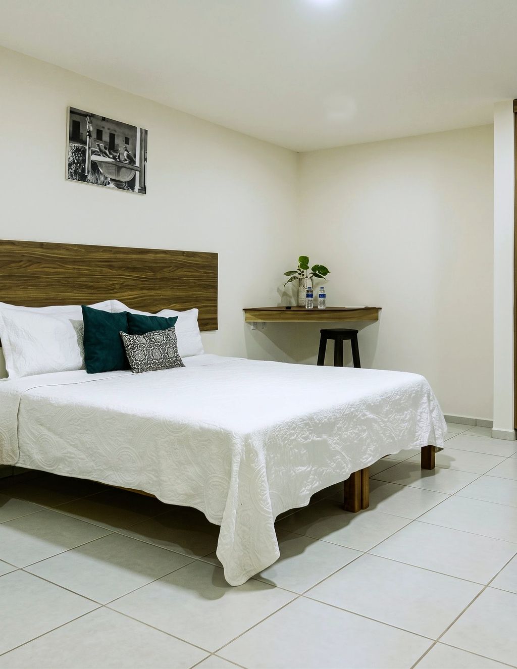 Habitación sencilla con una cama y cabecera de madera